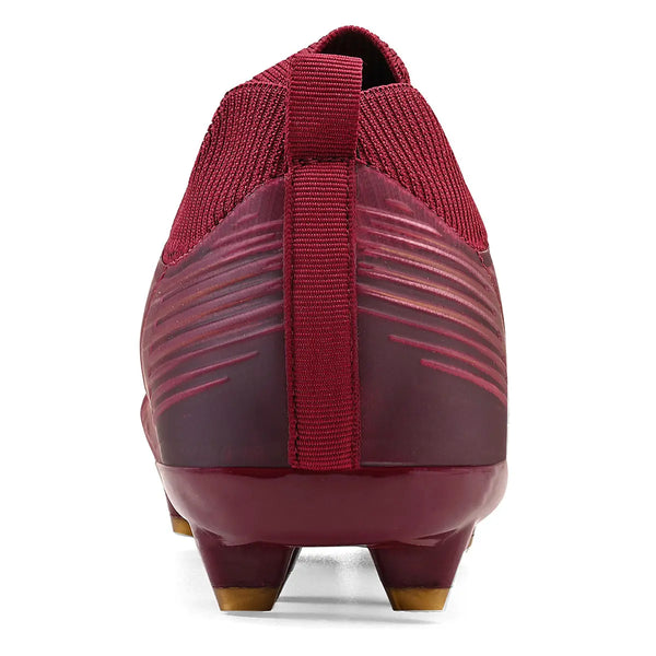 Imagem de um calçado esportivo de futebol na cor vinho com sola antiderrapante, pensando na pegada firme para jogos, destacando a parte de trás do tênis.