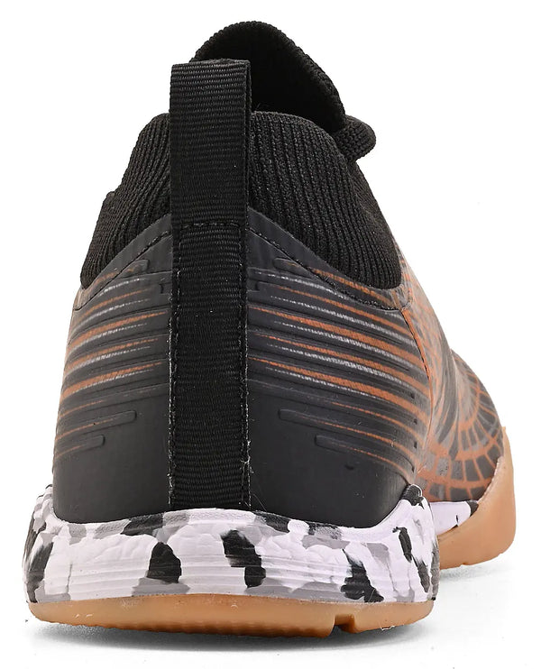 Chuteira preta e laranja com sola antiderrapante, foco na parte de trás, para corrida ou treino intenso.