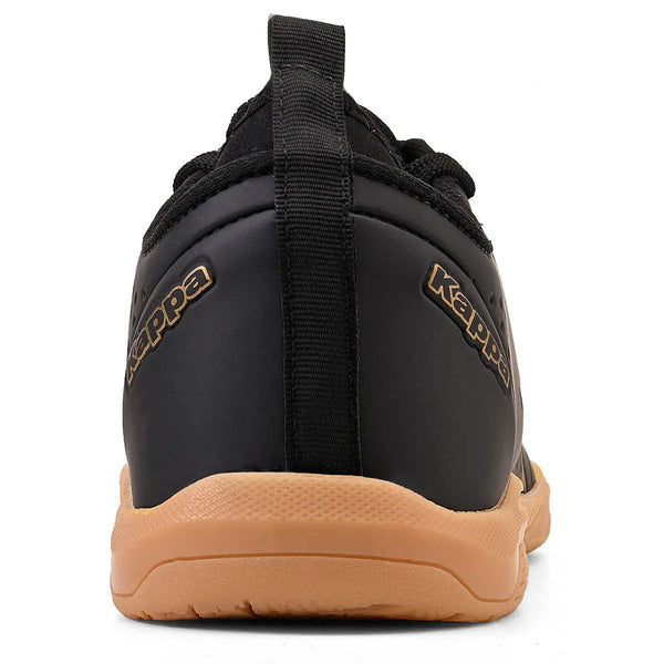 Imagem da parte de trás da chuteira preta, com detalhe de puxador preto no calcanhar, sola de borracha bege, ideal para atividades físicas.